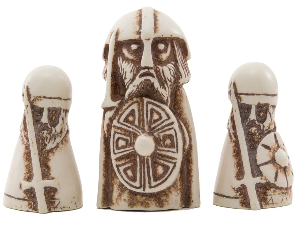 Three intricately designed Hnefatafl game pieces from The Viking Game, including a white King and two white Defenders.