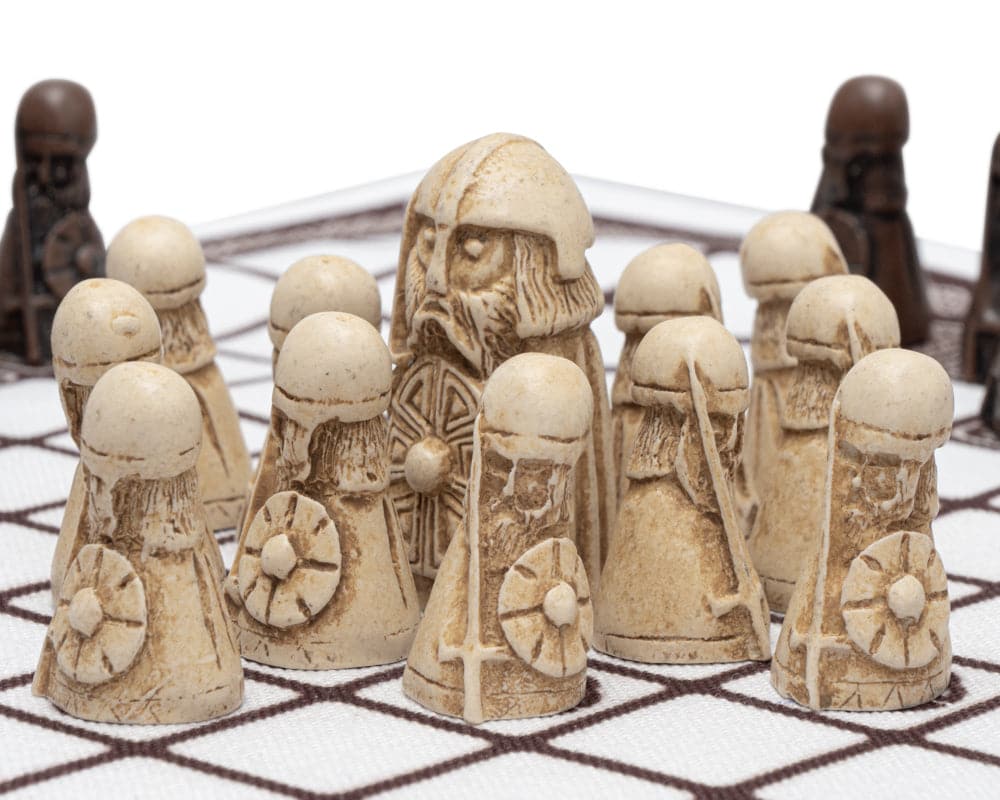 Hnefatafl game pieces on a checkered board, featuring detailed Viking-era warrior figurines.