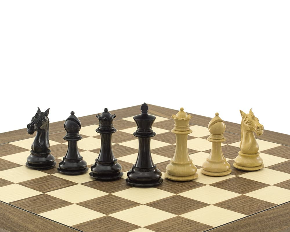 Columbus Series Chessmen Ebony 4-inch Staunton design pieces on chessboard, including ornate King, Queens, and Knights, handcrafted from ebony.