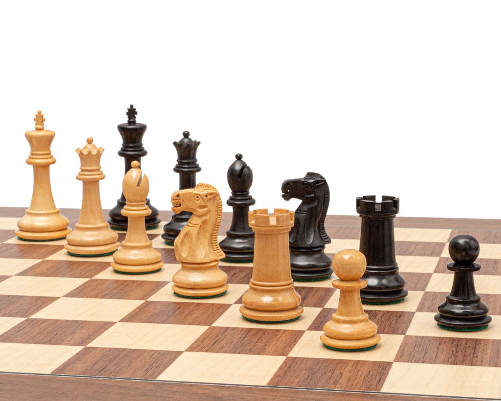 The Warwick Series 3.25 Inch Ebonised Chessmen in traditional Staunton design displayed on a chessboard, featuring superb detail and finish.