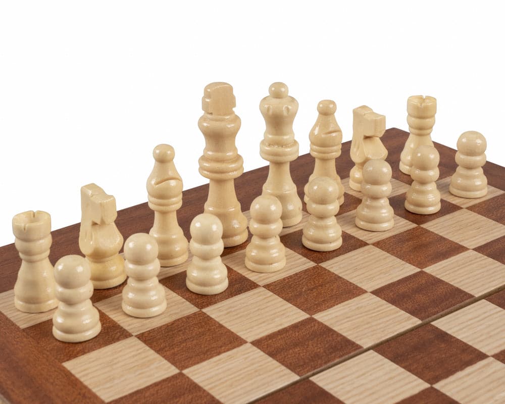 Close-up of chess pieces on a mahogany travel-size backgammon and chess set with a checkered board.